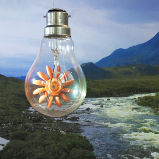 A light bulb containing a turbine hanging in mid-air above a stream leading to mountains