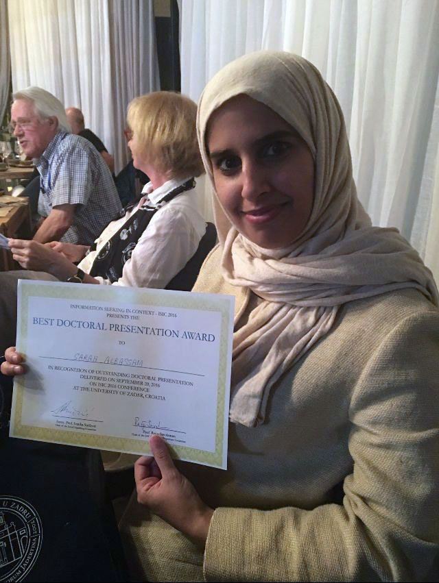 Sarah Albassam, a PhD student, holds a certificate for the 'best doctoral presentation award'