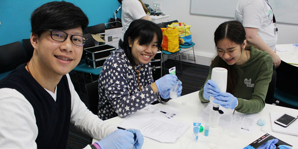 summer school 2017 students working in the lab smiling at the camera