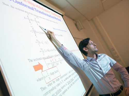a lecturer pointing at the board