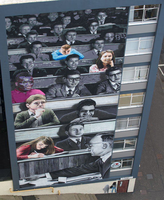 Students of the past and present painted on the gable end of Graham Hills Building on North Portland St