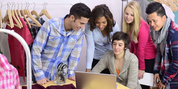 Young entrepreneurs gather round a laptop.