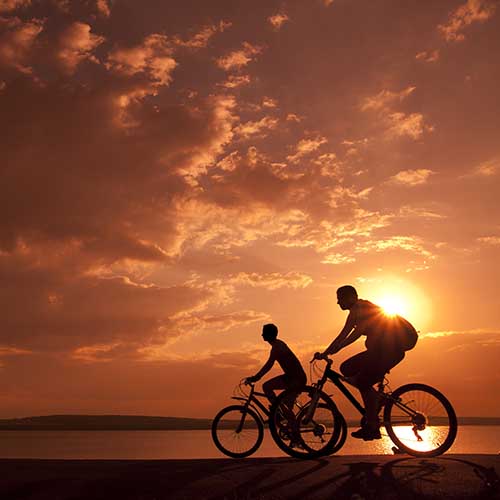 Couple cycling at sunset