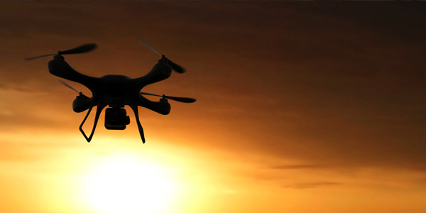 Unmanned flying drone in the sunset