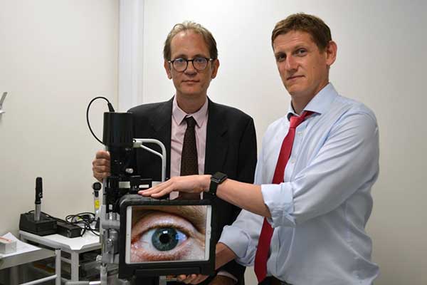 Dr Mario Giardini & Dr Iain Livingstone with a slit lamp used in virtual eye testing.