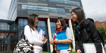 Three Student Girls Laughing Carrying Folders 360x180