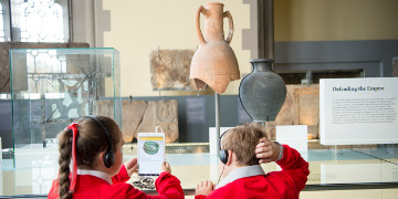 Two children looking at an tablet, learning about the Romans