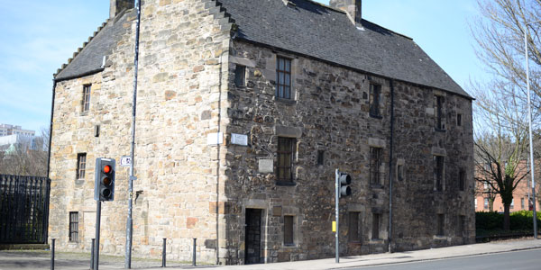 an exterior shot of the oldest house in glasgow, a yellow sandstone building on cathedral street