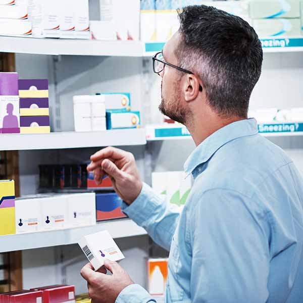 Pharmacist looking at drugs on a shelf Pharmacist looking at drugs on a shelf