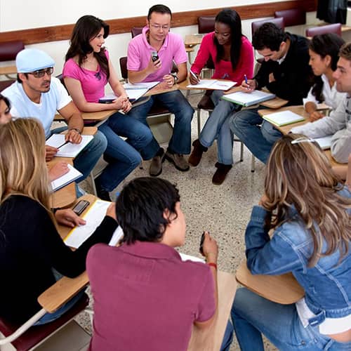 students sitting in a circle talking and taking notes