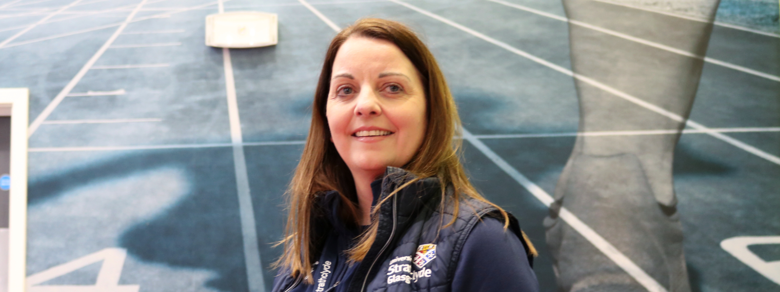 Cara Lamb, a teaching fellow and academic, standing in a gym hall in the Strathclyde Sport building