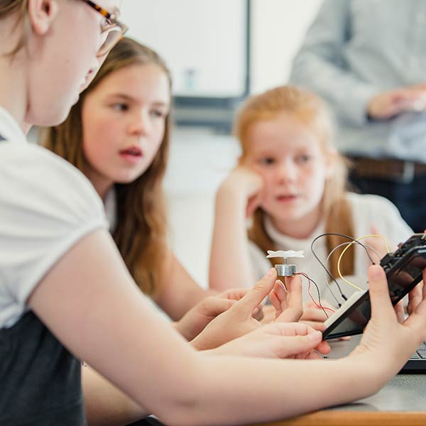 Students are following instructions on a laptop to make a propeller spin by building an electrical circuit. Students are following instructions on a laptop to make a propeller spin by building an electrical circuit.