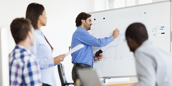 People in business discussing project at whiteboard.
