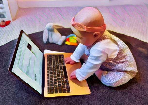 A baby typing on a laptop