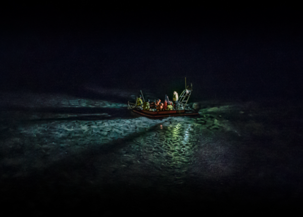 A boat with researchers in the middle of the ocean at night