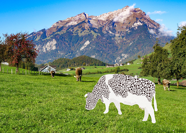 Cows in a field with mountains behind them. Cow at the front has been graphically illustrated with molecule patterns
