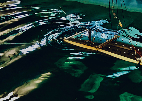 A hinged platform floating in a large tank of water  