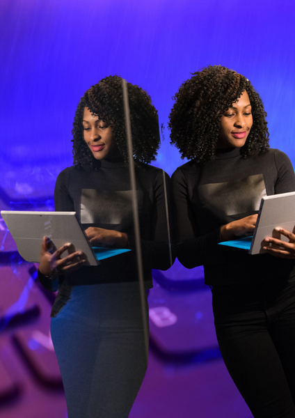 Black woman on laptop reflected in mirror