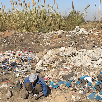 A lone man scours the rubbish dumped on the fringe of Cairo