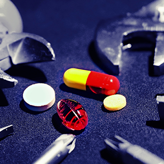 An assortment of colourful pills lie surrounded by tools