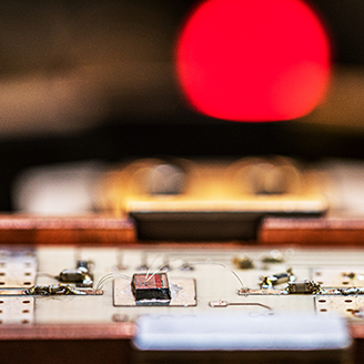 Close up of a circuit board with a red LED light in the background mimicking a sunset