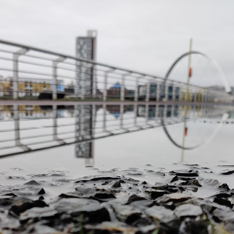 A flooded walkway next to a river in a city