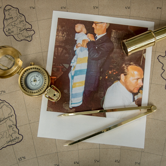 A polaroid family photo on a map with a compass and navigation equipment