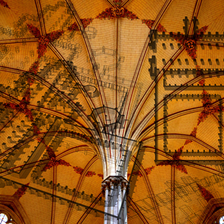 A creative composite image of an ornate cathedral ceiling overlaid with architectural plans
