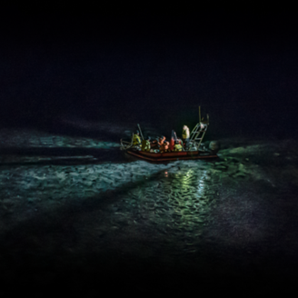 A boat with researchers in the middle of the ocean at night
