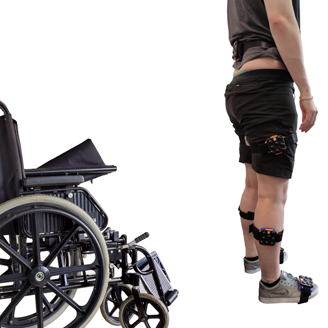 A wheelchair, followed by a person standing, followed by a person walking away