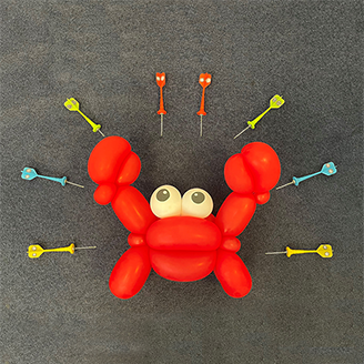 A red balloon crab, surrounded by darts with pictures of vesicles on them pointing at the crab