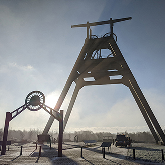 A fixed pulley structure on an old mining site with the sun shining through