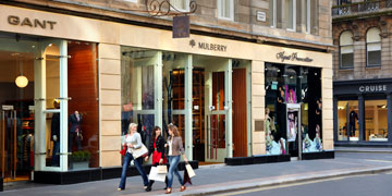 three women shopping and walking past shops on Glasgow's Ingram Street