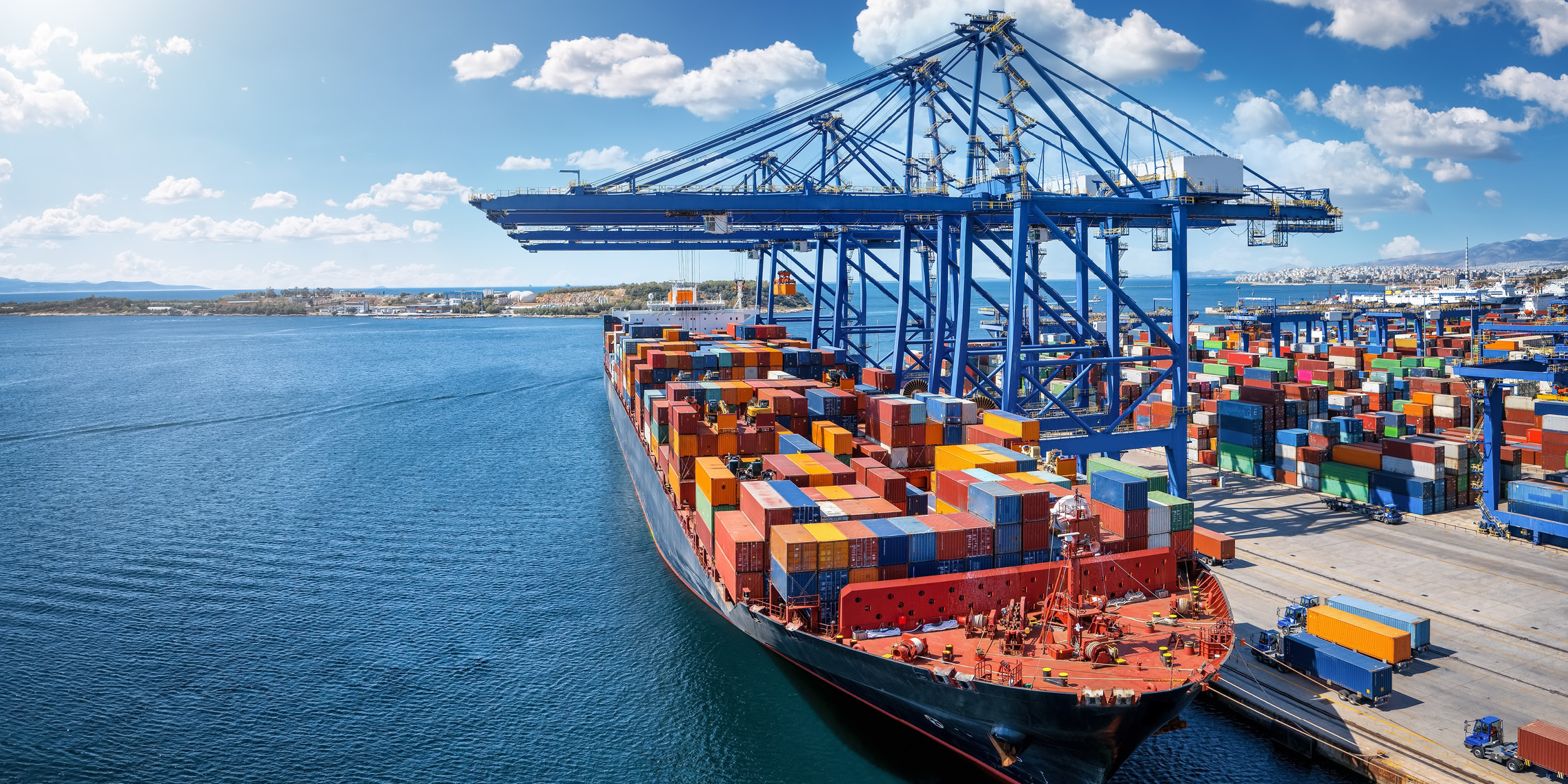 A cargo ship loaded with shipping containers docked at a marine port