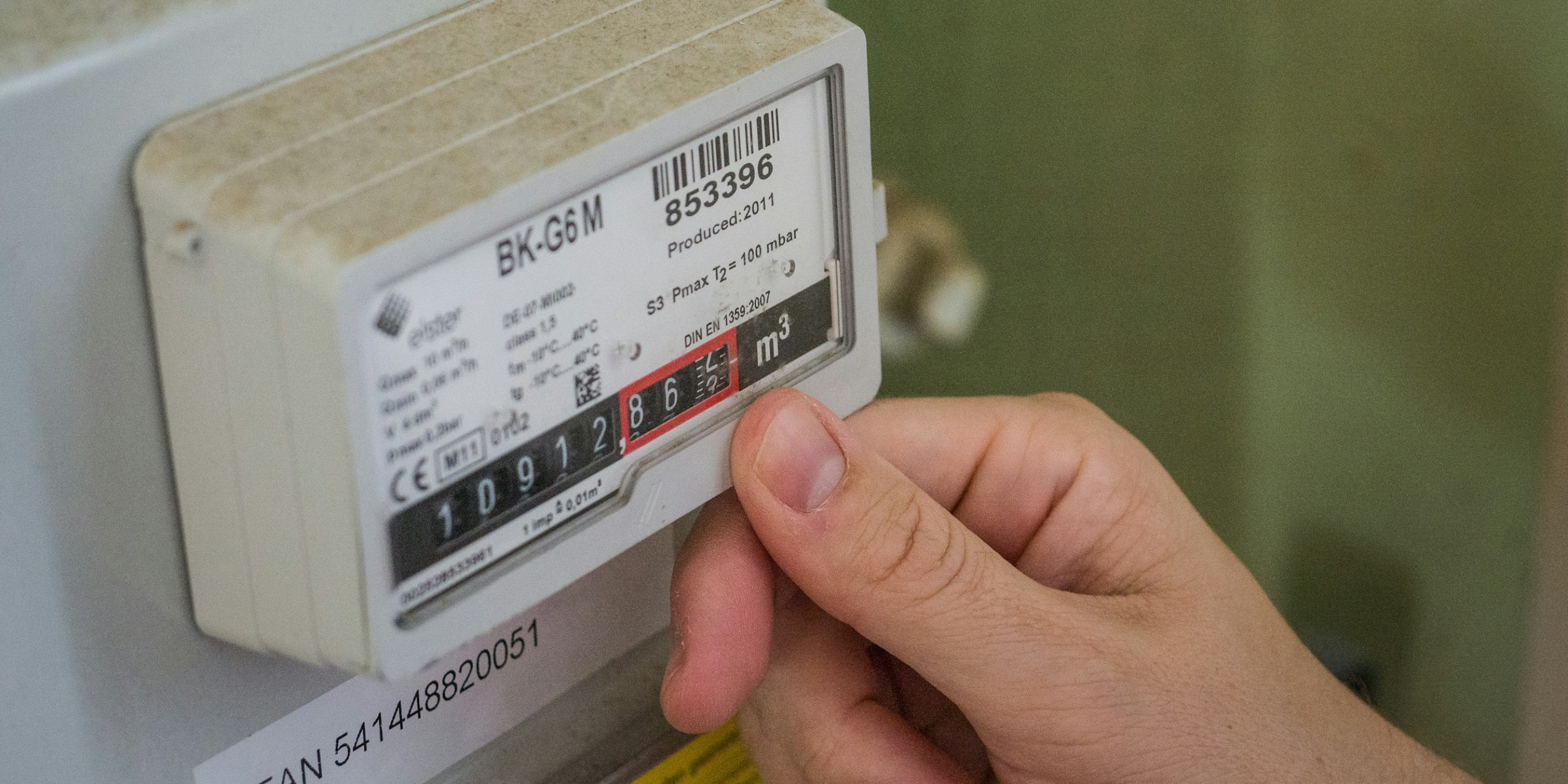Someones hand next to an energy meter