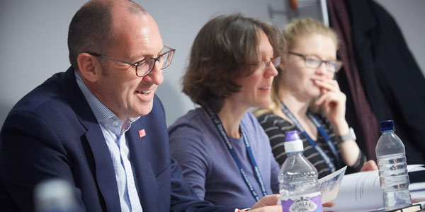 a man and two woman sit smiling during a centre for lifelong learning class