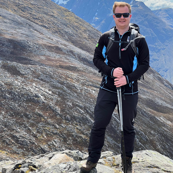 Donald roberston on a hill in walking gear smiling at the camera