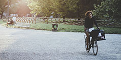 A woman rides a bike through a park