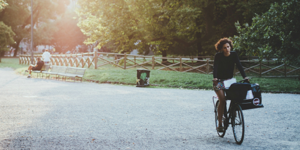 Woman riding bike through park