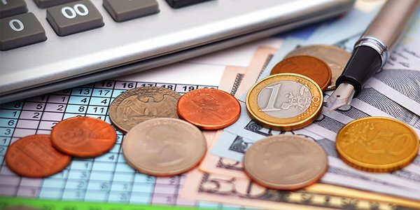 Coins next to financial paperwork and calculator