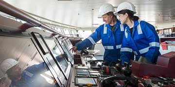 Workers survey a ship's systems.