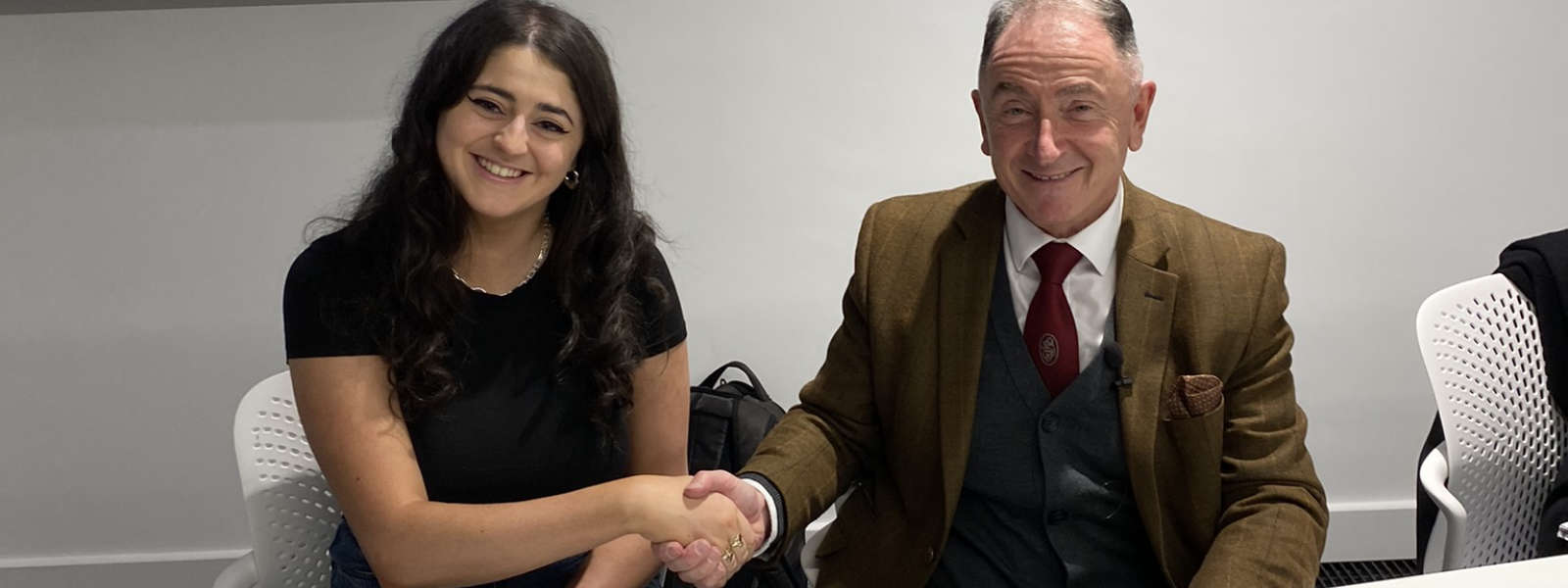 Strath Union President Eva Curran shakes hands with Professor Sir Jim McDonald, Principal of the University of Strathclyde