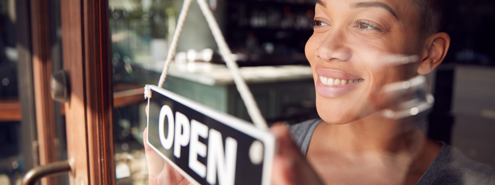 Female entrepreneur with shop open sign