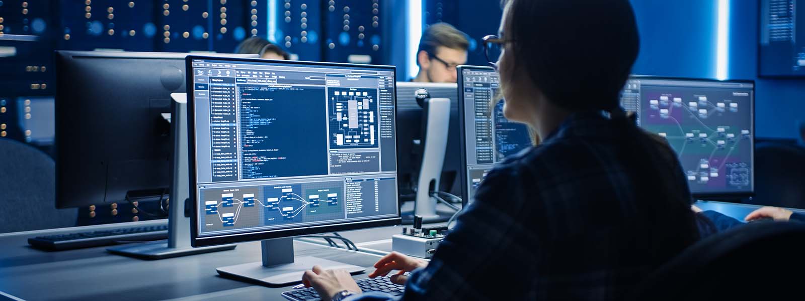 A woman sitting at computer screens