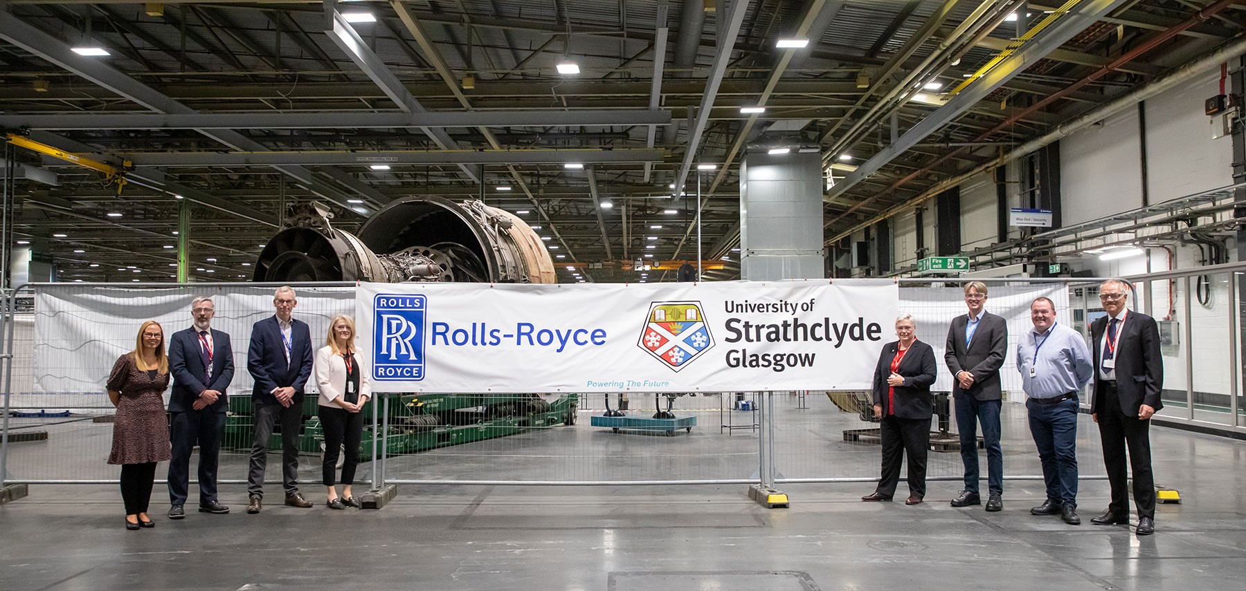 Rolls-Royce and Strathclyde staff standing together. Left to right: Lindsay Gardner – Senior Business Partner, Rolls-Royce; Matthew Maynard, University of Strathclyde; Nigel Bird - Executive Vice President, Rolls-Royce; Jacqueline Redmond, Executive Director, PNDC, University of Strathclyde; Gillian Docherty, Chief Commercial Officer, University of Strathclyde; Rob Watson, Head of Civil Aerospace, Rolls-Royce; Gordon Hutcheson, Manufacturing Executive, Rolls-Royce; and Derek Boyd, Project Director, University of Strathclyde.