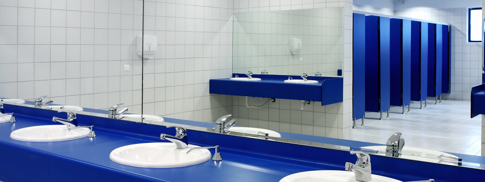 Row of sinks and cubicles in public toilet