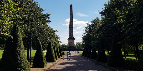 People walking towards Nelson Monument in Glasgow Green