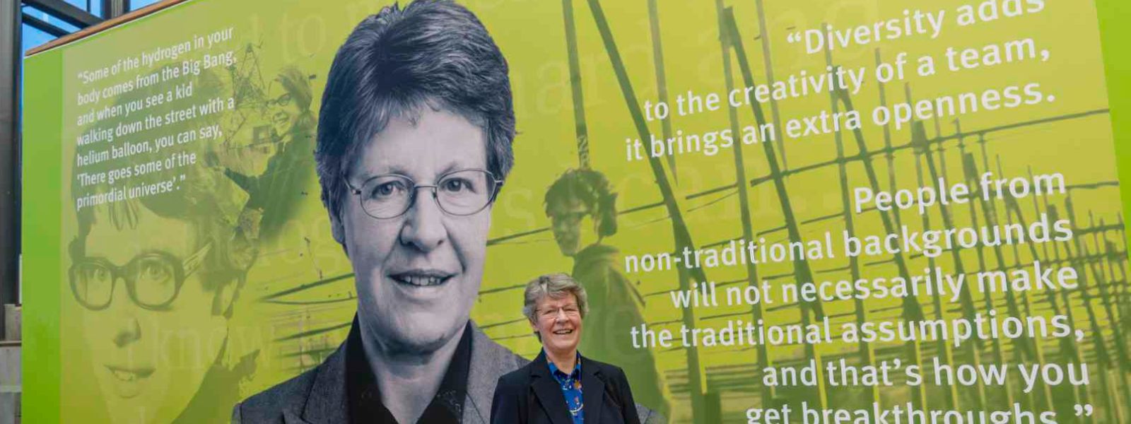 Professor Dame Jocelyn Bell stands in front of a mural dedicated to her at the University of Strathclyde