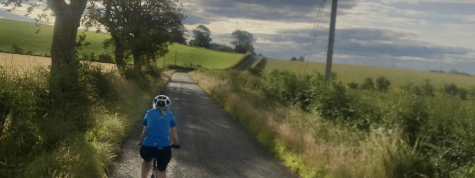 Conference and Events Officer Sarah McLeary cycles her bike along a countryside road