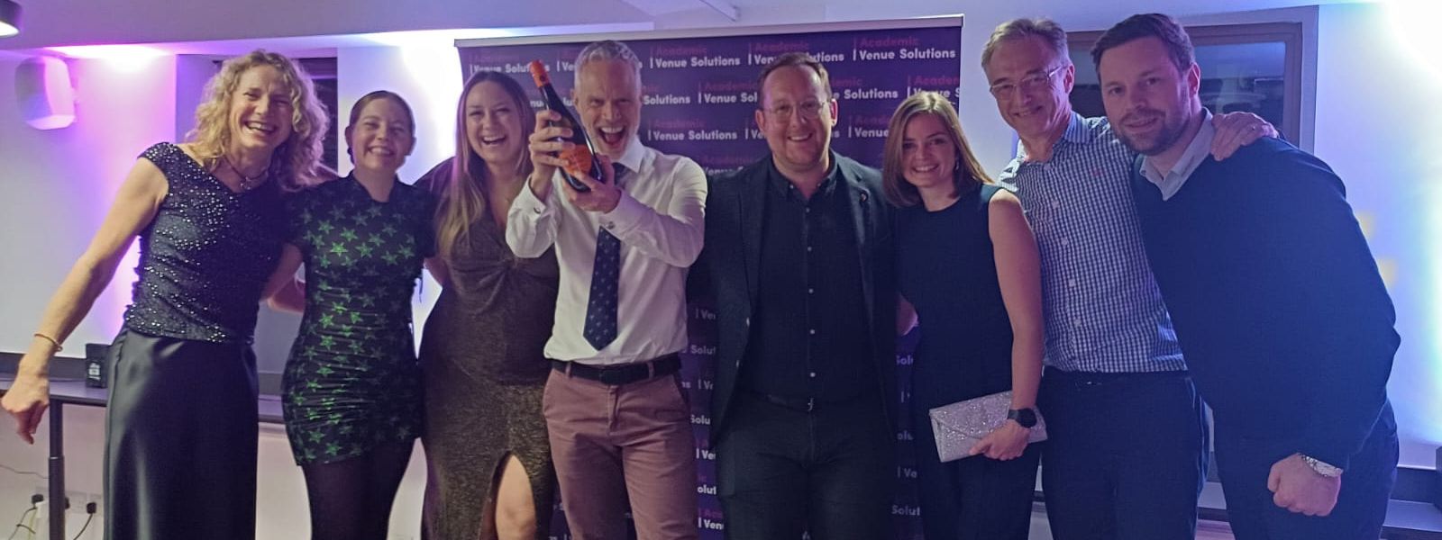 Members of the Conferencing and Events Team and conference delegates holding a bottle of bubbly to celebrate a quiz win Members of the Conferencing and Events Team and conference delegates holding a bottle of bubbly to celebrate a quiz win